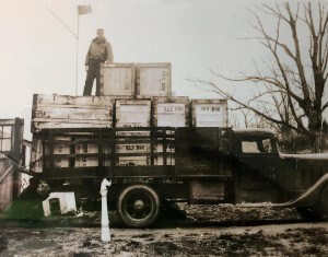 A vintage photo of a person unloading from a truck.