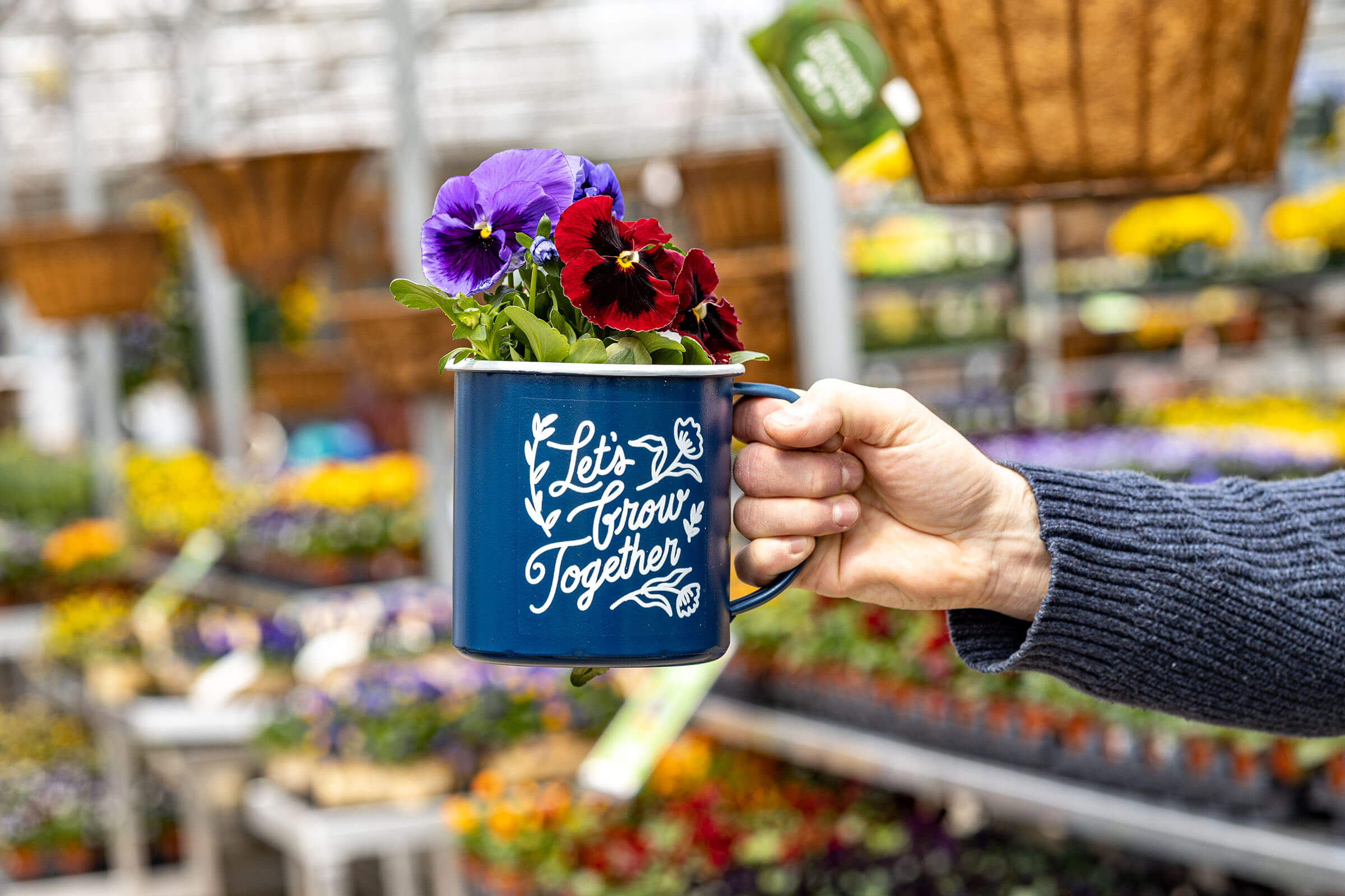 A mug filled with colorful flowers with the words Let's Grow Together written across the mug.